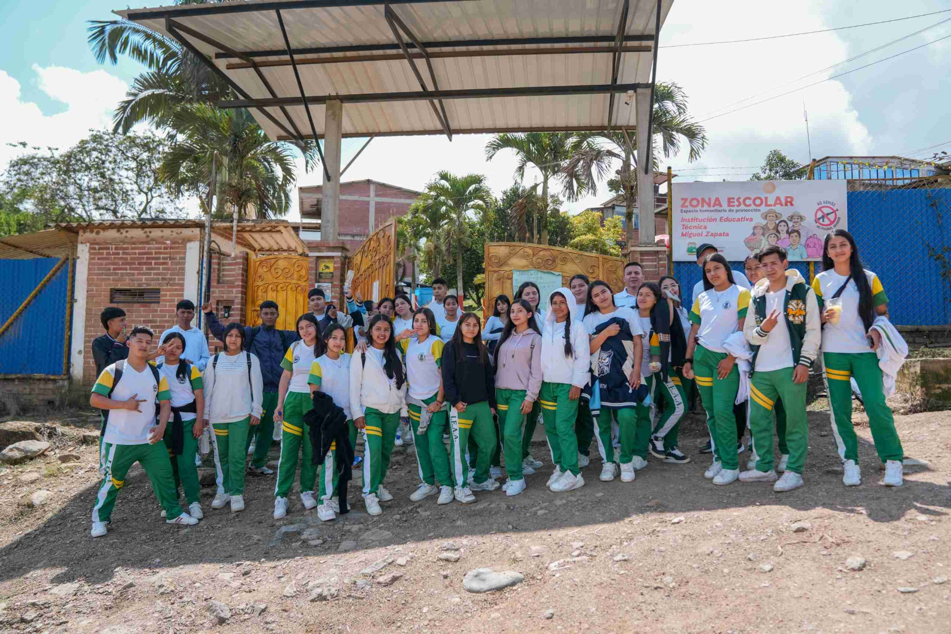 Estudiantes de la Institución Educativa Técnica Miguel Zapata posando fuera de la institución junto a representantes de la IU Digital de Antioquia.