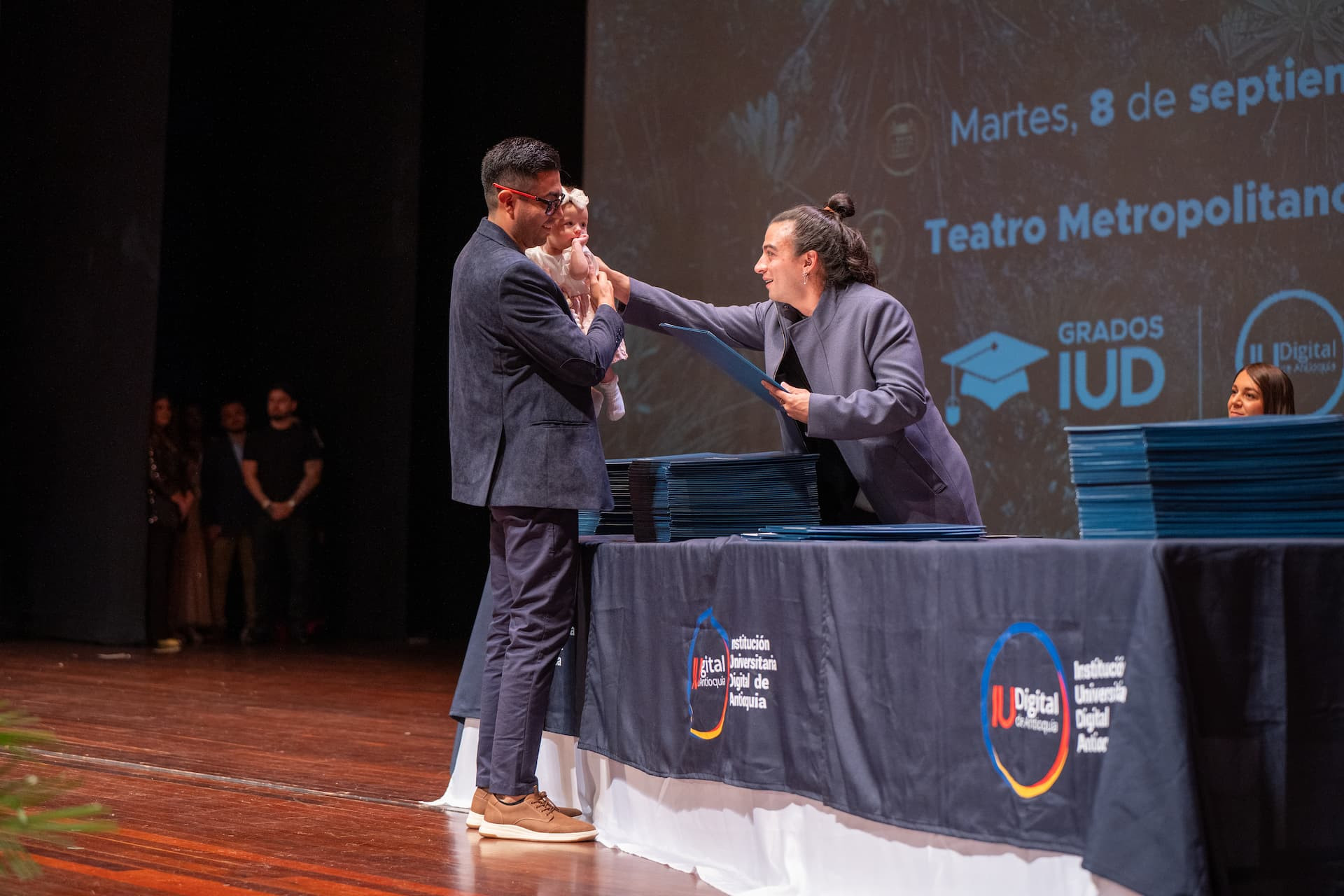 Decano entrada diploma a graduado de la IU Digital de Antioquia durante la ceremonia de grados